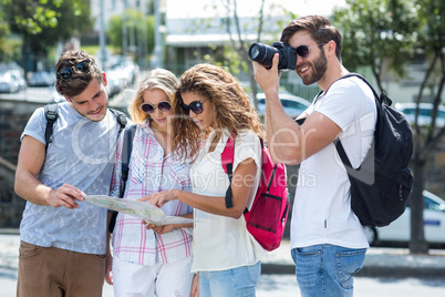 Hip friends holding map and taking picture