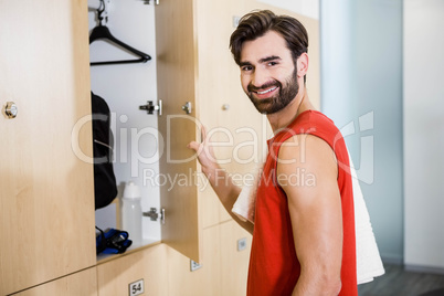 Smiling man opening locker