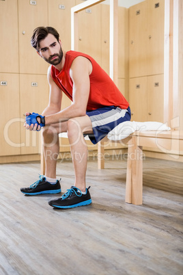 Unsmiling man sitting in locker room