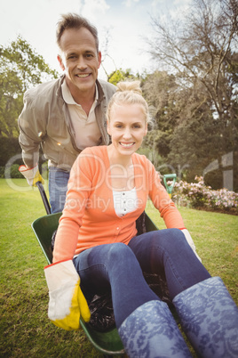 Husband pushing wife in a wheelbarrow