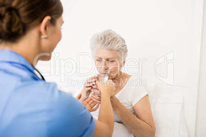 Nurse taking care of suffering senior patient