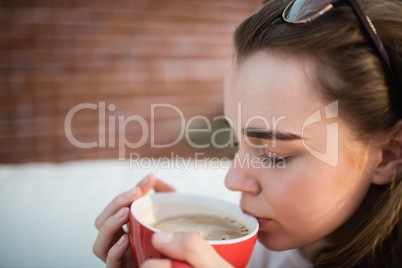 Pretty woman relaxing on couch with coffee