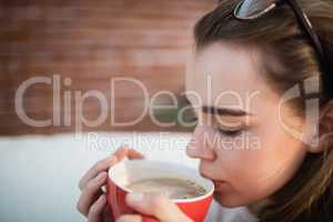 Pretty woman relaxing on couch with coffee