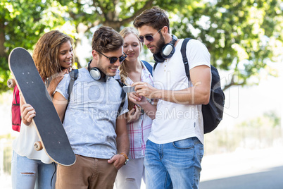 Hip friends looking at smartphone