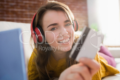 Young woman using her credit card to buy online