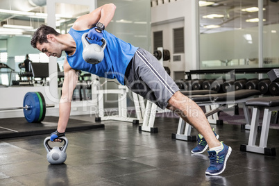 Muscular man doing exercises with kettlebells