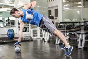 Muscular man doing exercises with kettlebells