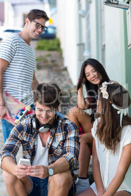 Hip friends sitting on steps and talking