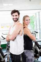 Fit couple standing back to back with arms crossed