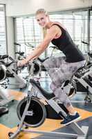 Smiling woman using exercise bike