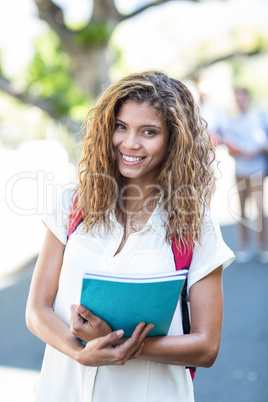Hip woman holding notebook and smiling at the camera Hip woman holding notebook and smiling at the camera
