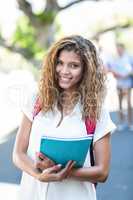Hip woman holding notebook and smiling at the camera