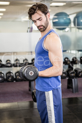 Muscular man lifting dumbbell