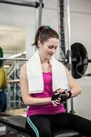 Smiling woman sitting on barbell bench