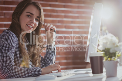 Smiling hipster businesswoman watching computer