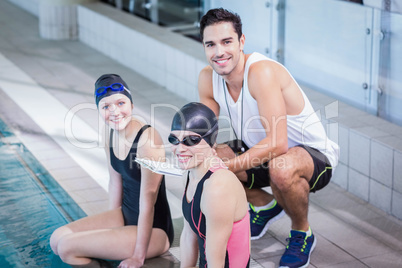 Trainer and swimmers smiling at the camera