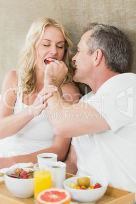 Husband giving a strawberry to wife