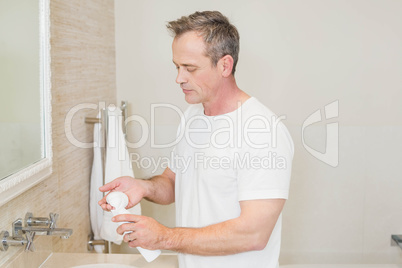 Handsome man applying cream