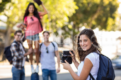 Hip woman taking picture of her friends