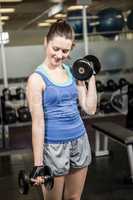 Fit woman lifting dumbbells