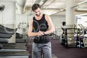 Smiling man on treadmill looking at smartwatch