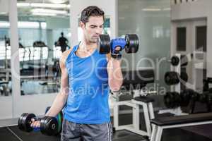 Muscular man lifting dumbbells