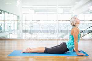 Fit blonde doing yoga on mat