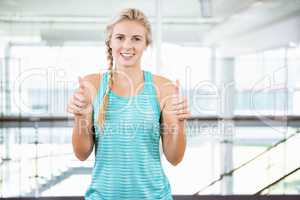 Smiling blonde standing and showing thumbs up