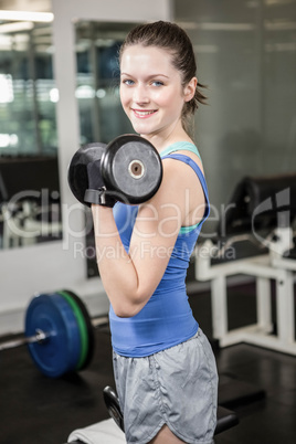 Fit woman lifting dumbbell