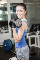 Fit woman lifting dumbbell