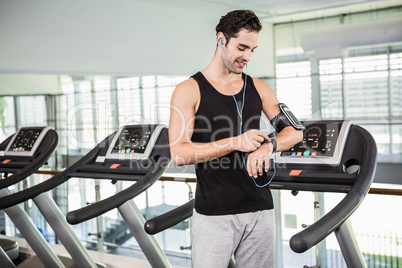 Smiling man on treadmill using smart watch