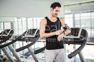 Smiling man on treadmill using smart watch