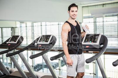 handsome man on treadmill drinking water