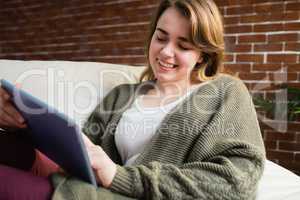 Pretty woman using tablet lying on the couch