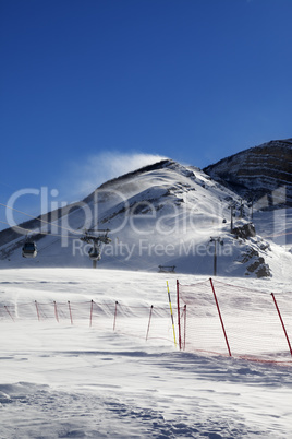 Gondola lift on ski resort at windy sun day