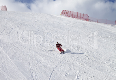 Skier on ski slope at sun day