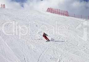 Skier on ski slope at sun day