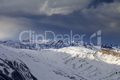 Winter mountains at evening and storm clouds