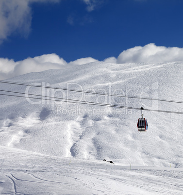 Gondola lift and ski slope at sun day