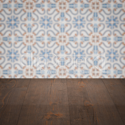 Wood table top and blur vintage ceramic tile pattern wall