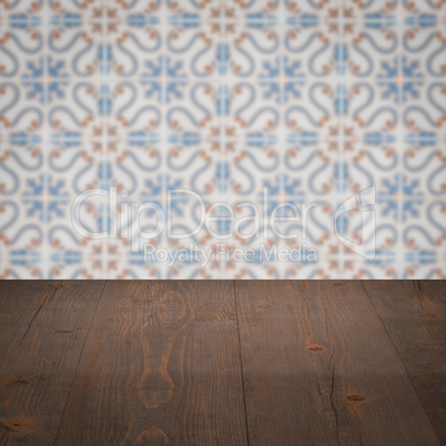 Wood table top and blur vintage ceramic tile pattern wall