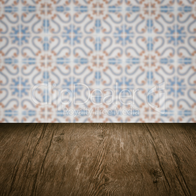 Wood table top and blur vintage ceramic tile pattern wall