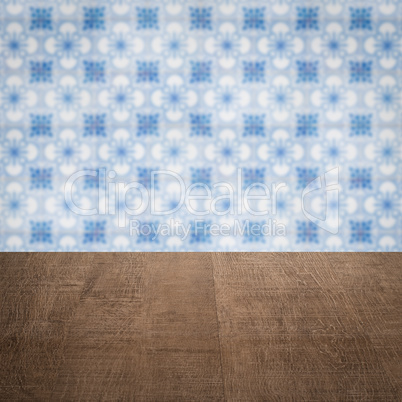 Wood table top and blur vintage ceramic tile pattern wall