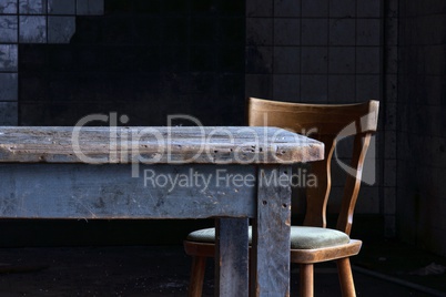Holztisch mit Stuhl in gekacheltem Raum