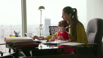 2 Mother With Child Entrepreneur Using Tablet In Office