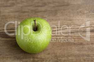 Green apple on wooden background
