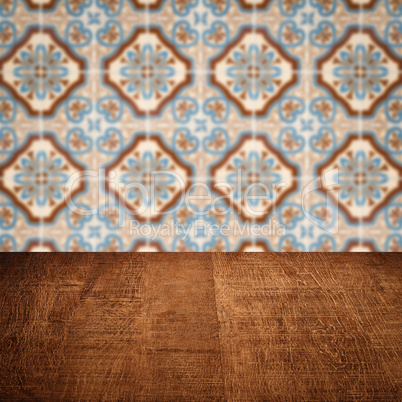 Wood table top and blur vintage ceramic tile pattern wall