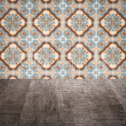 Wood table top and blur vintage ceramic tile pattern wall