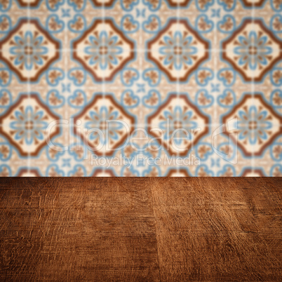 Wood table top and blur vintage ceramic tile pattern wall