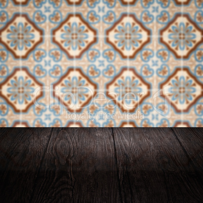 Wood table top and blur vintage ceramic tile pattern wall